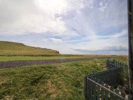 A view of a grassy area with a path and hills near the sea at Caravan A7 in Bridport
