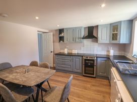 A kitchen with cabinets and a dining table at Abinas in Kenmare