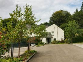 A house with a driveway and trees at Flat 4 Grasmere Lodge Ambleside