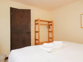 A bedroom with a bed and wooden rack at Dunmail Raise, Grasmere Lodge in Grasmere