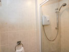 A shower with tiles and a towel holder at Dunmail Raise, Grasmere Lodge in Grasmere