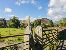 A gate with a public footpath sign and mountains in the background at Dunmail Raise, Grasmere Lodge, Grasmere