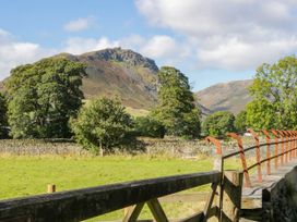 A view of mountains and trees with a fence in Dunmail Raise, Grasmere Lodge Grasmere