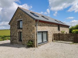 A stone house with windows and a fence at Reddaway Byre Okehampton