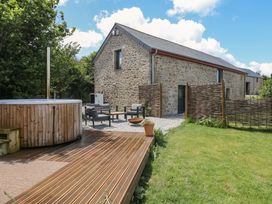 A garden with a hot tub and seating area at Reddaway Byre Okehampton