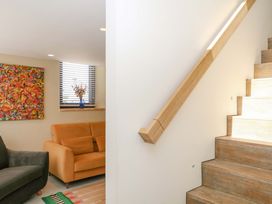 A living room with a sofa and stairs at Reddaway Byre Okehampton