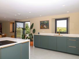 A kitchen with cabinets, sink and window at Reddaway Byre in Okehampton