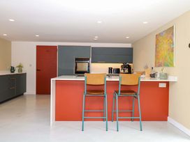 A kitchen with bar stools and appliances at Reddaway Byre Okehampton