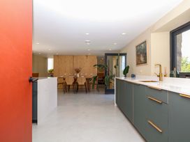 A kitchen with cabinets and a dining area at Reddaway Byre Okehampton