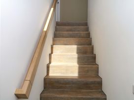 A staircase with wooden steps and a handrail at Reddaway Byre Okehampton