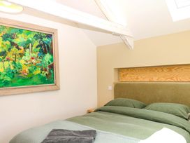 A bedroom with a bed and painting at Reddaway Byre Okehampton