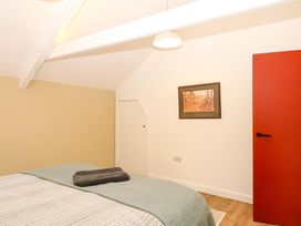 A bedroom with a bed and a red door at Reddaway Byre Okehampton