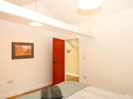 A bedroom with a bed and an open door at Reddaway Byre Okehampton