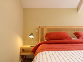 A bedroom with a bed and lamp at Reddaway Byre Okehampton