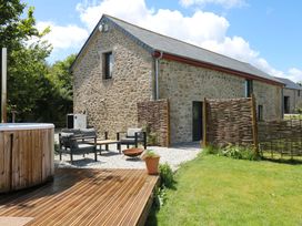 A house with a hot tub and seating area at Reddaway Byre Okehampton