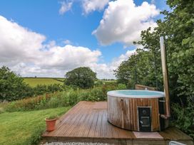 A hot tub on a wooden deck in an outdoor area at Reddaway Byre Okehampton