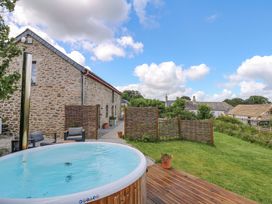 An outdoor area with a hot tub and garden at Reddaway Byre in Okehampton