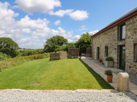 An outdoor space with a stone building and grass at Reddaway Byre Okehampton
