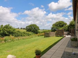 A garden with grass and trees at Reddaway Byre Okehampton