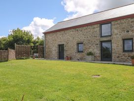 An outdoor view of a stone house with a garden at Reddaway Byre Okehampton