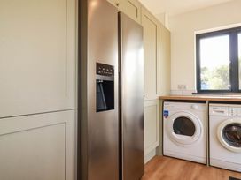 A kitchen with a refrigerator and washing machine at The Granary in Launceston