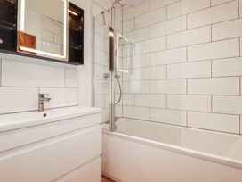 A bathroom with a bathtub and mirror at The Granary in Launceston
