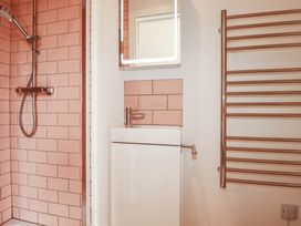 A bathroom with a shower, sink, and mirror at The Granary in Launceston