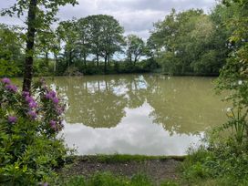 A pond surrounded by trees and flowers at Up Top in Launceston