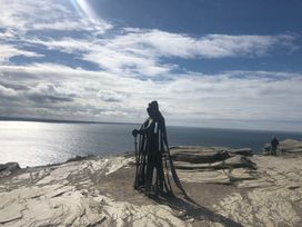 A statue overlooking the ocean on rocky terrain at Up Top in Launceston