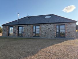 A stone building with multiple windows and a chimney at High View Barn in Launceston