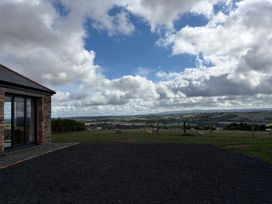 A house with clouds and fields in the background at High View Barn Launceston