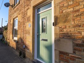 A front door with a window and brick wall at Corner House Wark
