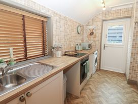 A kitchen featuring a sink, washing machine, and microwave at Corner House in Wark