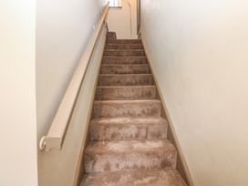 A staircase with carpet and handrail at Corner House in Wark