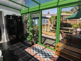 A conservatory with a refrigerator and plants at 11b Market Street, Narberth