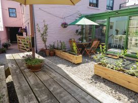 A garden with wooden furniture and plants at 11b Market Street Narberth