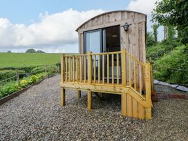 A wooden hut with steps on a gravel area at The Hut in Llandysul