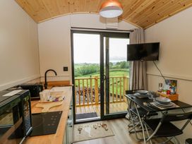 A kitchen with a table and chairs at The Hut in Llandysul