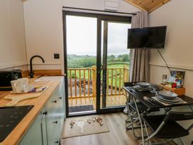 A kitchen with a dining table and a view at The Hut in Llandysul