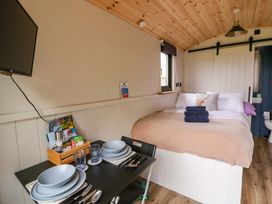 A bedroom with a bed and dining table at The Hut in Llandysul