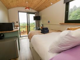 A bedroom with a bed and towels at The Hut in Llandysul