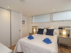 A bedroom with a bed and nightstands at 5 Sails in Dartmouth