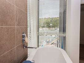 A bathroom with a bathtub and a view of the harbor at 5 Sails in Dartmouth