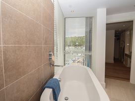 A bathroom with a bathtub and window at 5 Sails in Dartmouth