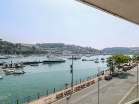 A view of boats on the water and a street lined with benches at 5 Sails Dartmouth