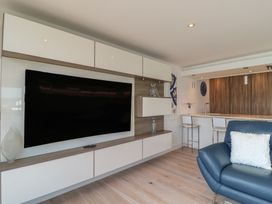 A living room with a television and bar stools at 5 Sails in Dartmouth