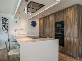 A kitchen with a large island and bar stools at 5 Sails in Dartmouth