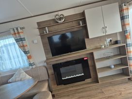 A living room with a television and fireplace at Unity Beach in Burnham-on-Sea