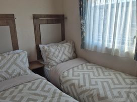 A bedroom with two beds and a window at Unity Beach - Abi Ryedale in Burnham-on-Sea
