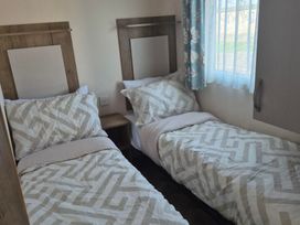 A bedroom with two beds and a window at Unity Beach - Abi Ryedale in Burnham-on-Sea